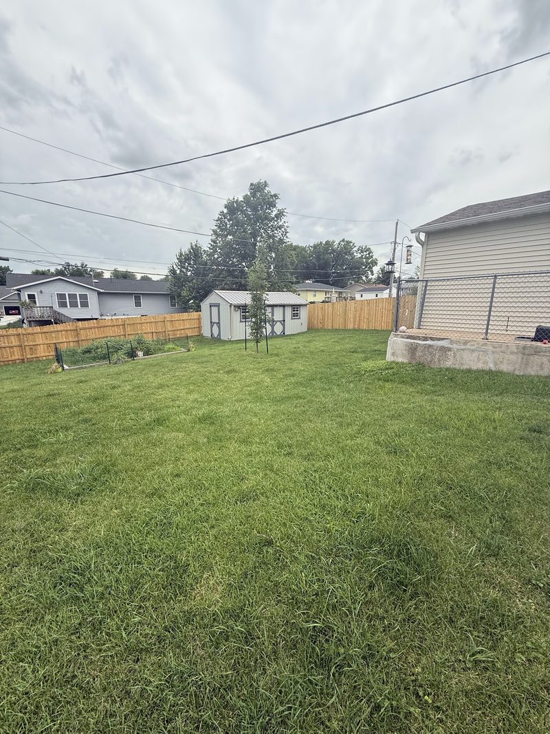 Backyard with a concrete pad, shed and finished grading