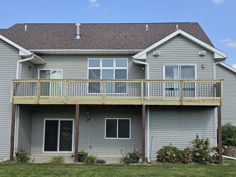Large elevated wood deck built on the back of a two-story home